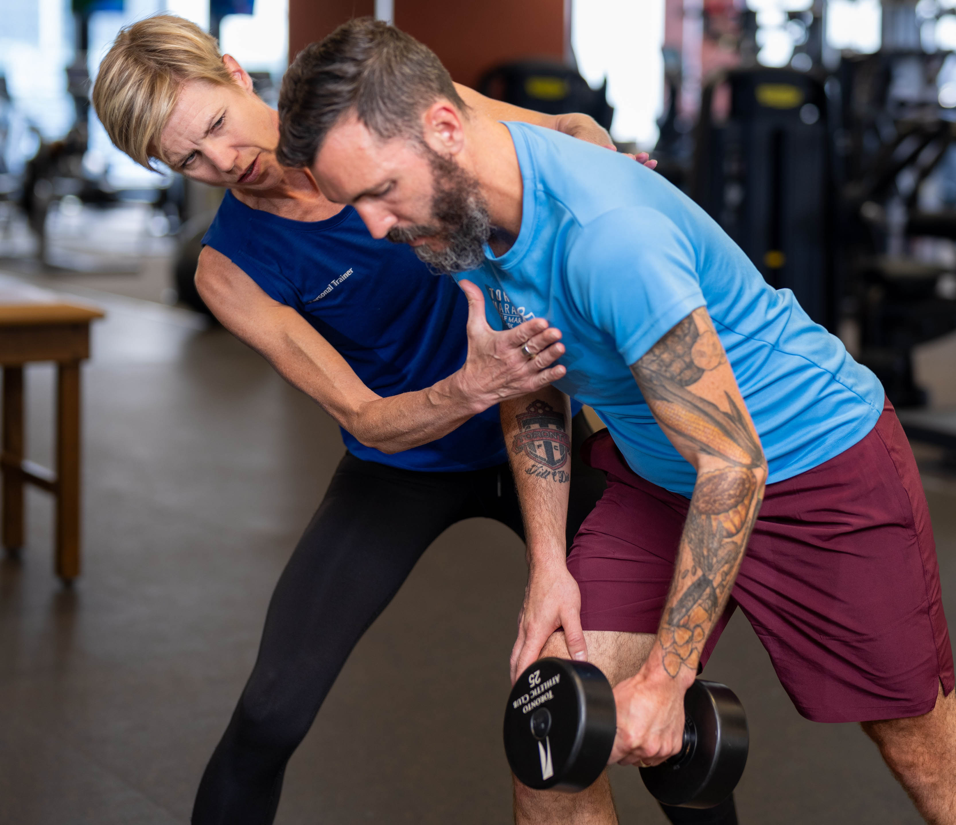 Female trainer from the Toronto Athletic Club (Meg Sharp) training with her male client on the gym floor